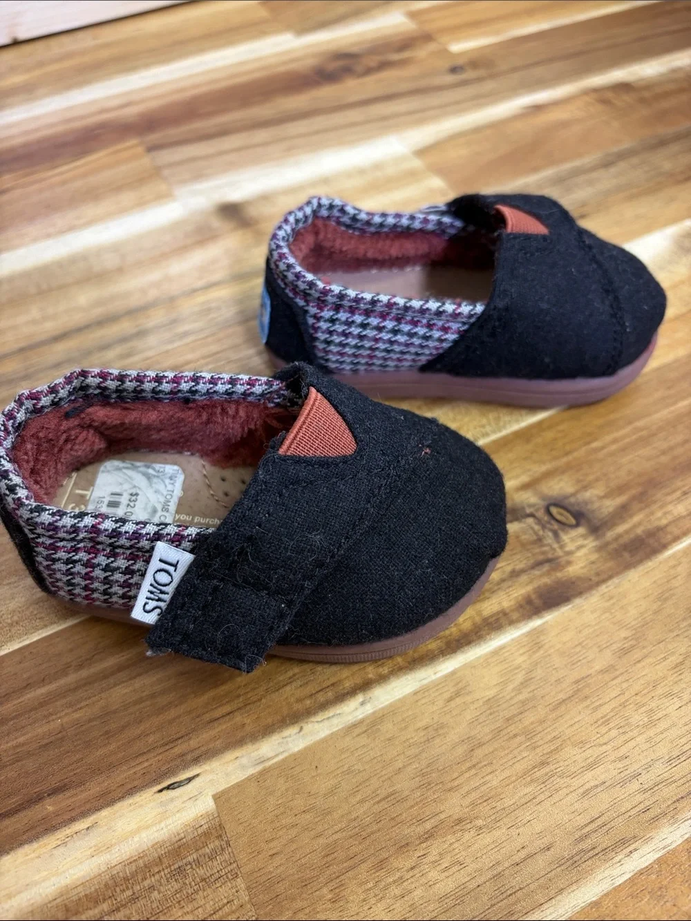 Toms Black Baby Slip-Ons with Rust Accent and Patterned Trim